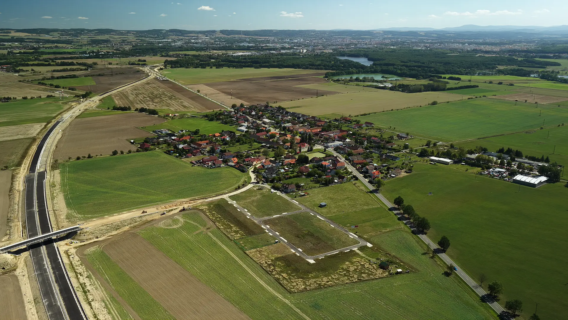 Letecký pohled na stavební místo projektu Bydlení u Bezdrevu v Dasném